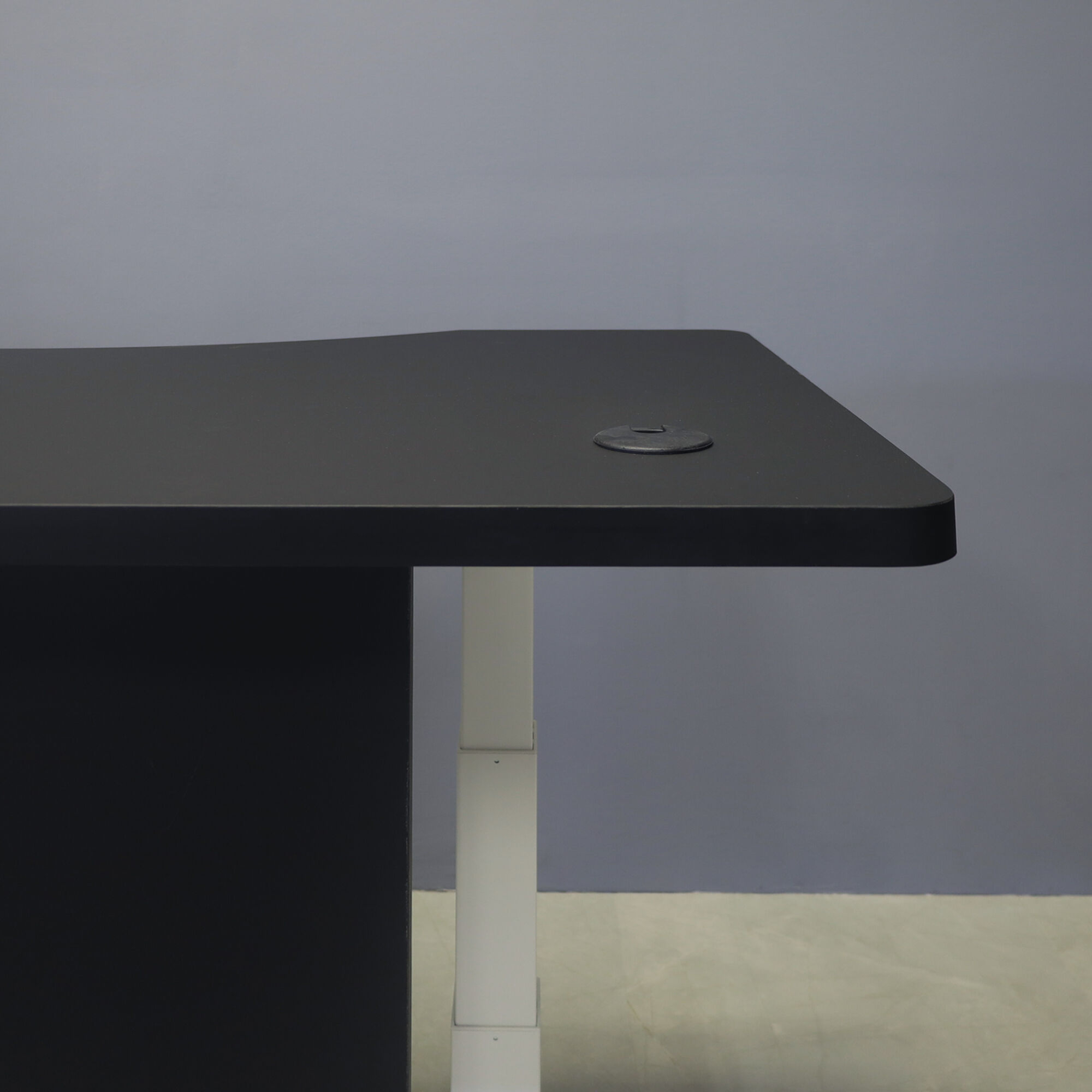 60-inch aXis Sit-stand Executive Desk with black traceless laminate top & privacy panel, and white metal legs, shown here.