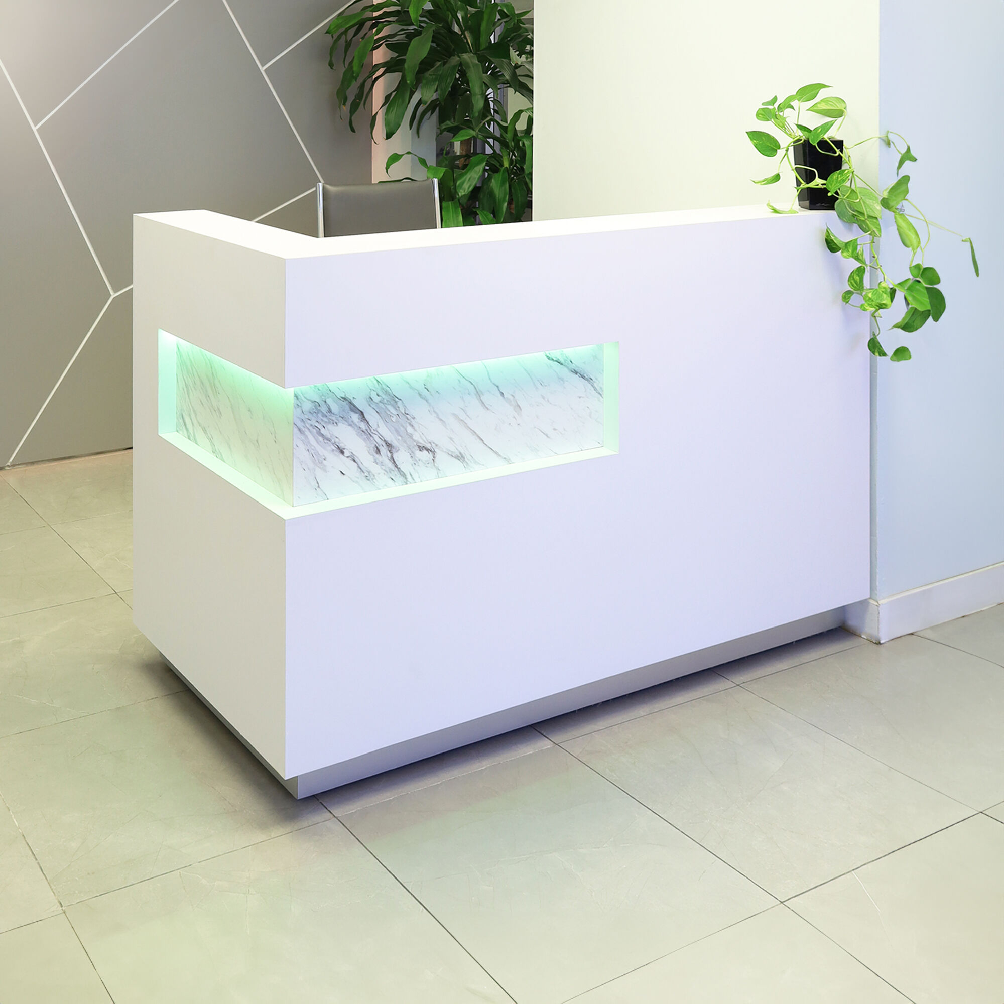 60-inch Manhattan L-Shape Custom Reception Desk in calcutta stone pvc laminate accent panel, and white matte laminate main desk. Brushed aluminum toe-kick, with multi-colored LED, shown here.