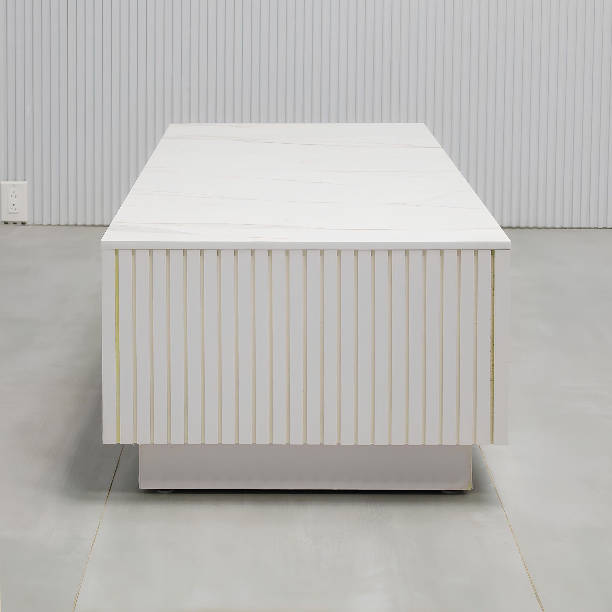 60-inch Norfolk Rectangular Lobby Table with solenne engineered surface top, white gloss tambour side table, and white gloss laminate toe-kick.