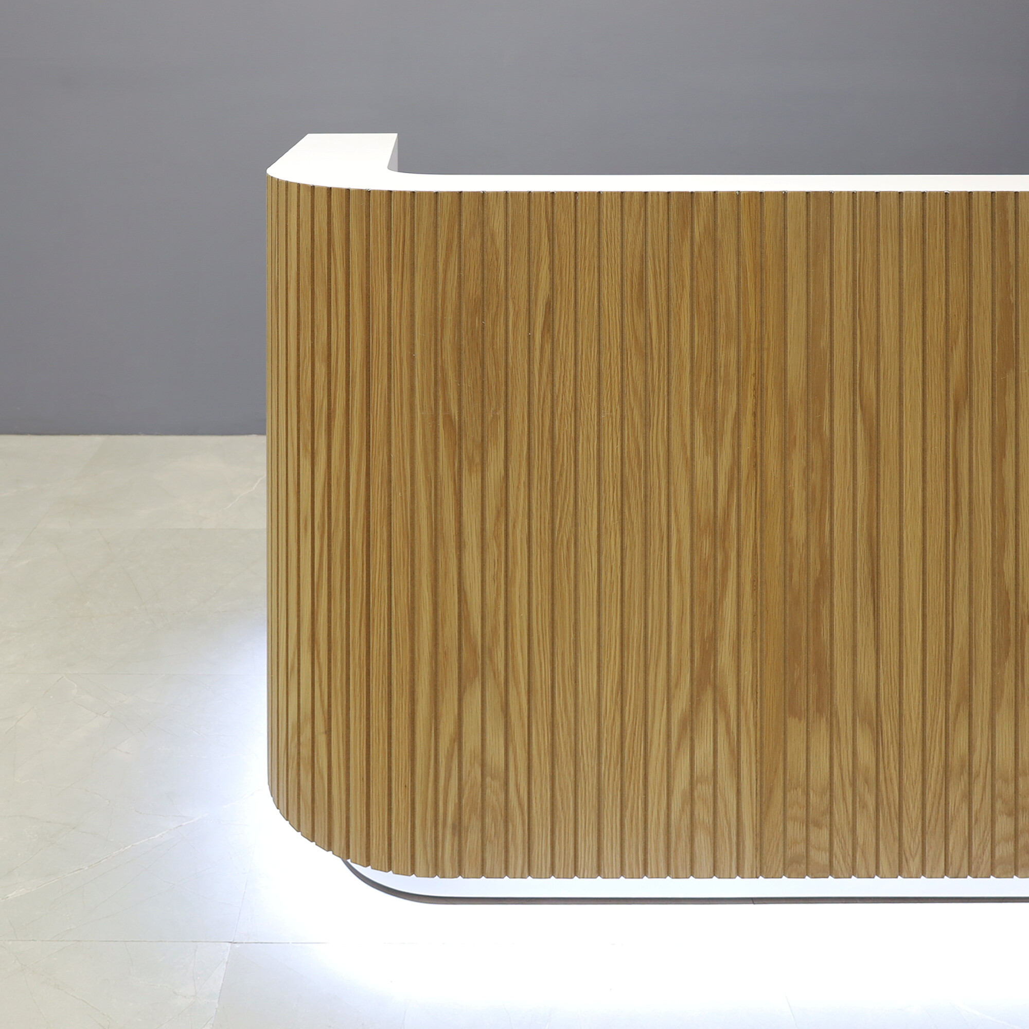 90-inch Nola Custom Reception Desk in white oak tambour main desk, white matte laminate workspace & toe-kick, and white LED.